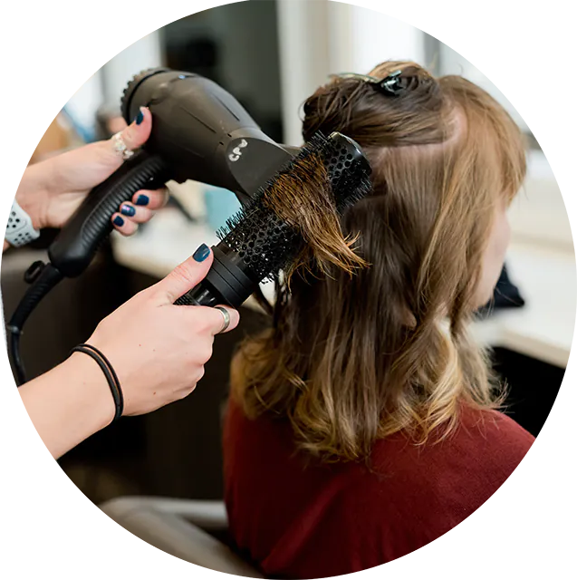 Einer Frau werden die Haare geföhnt