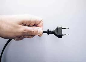 Hand mit Netzstecker